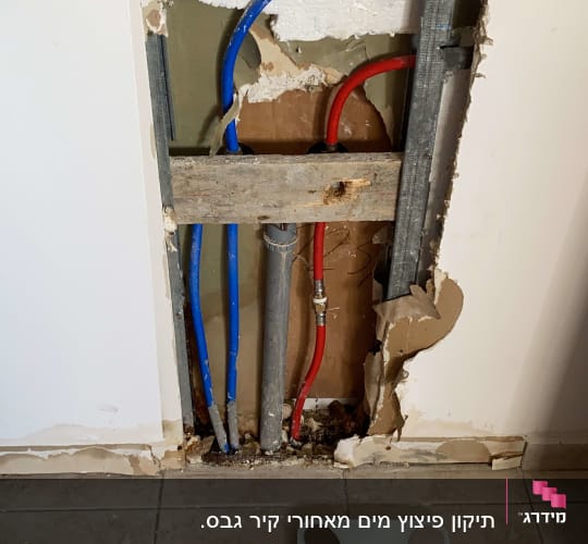צינורות מים כחולים ואדומים בקיר פתוח
